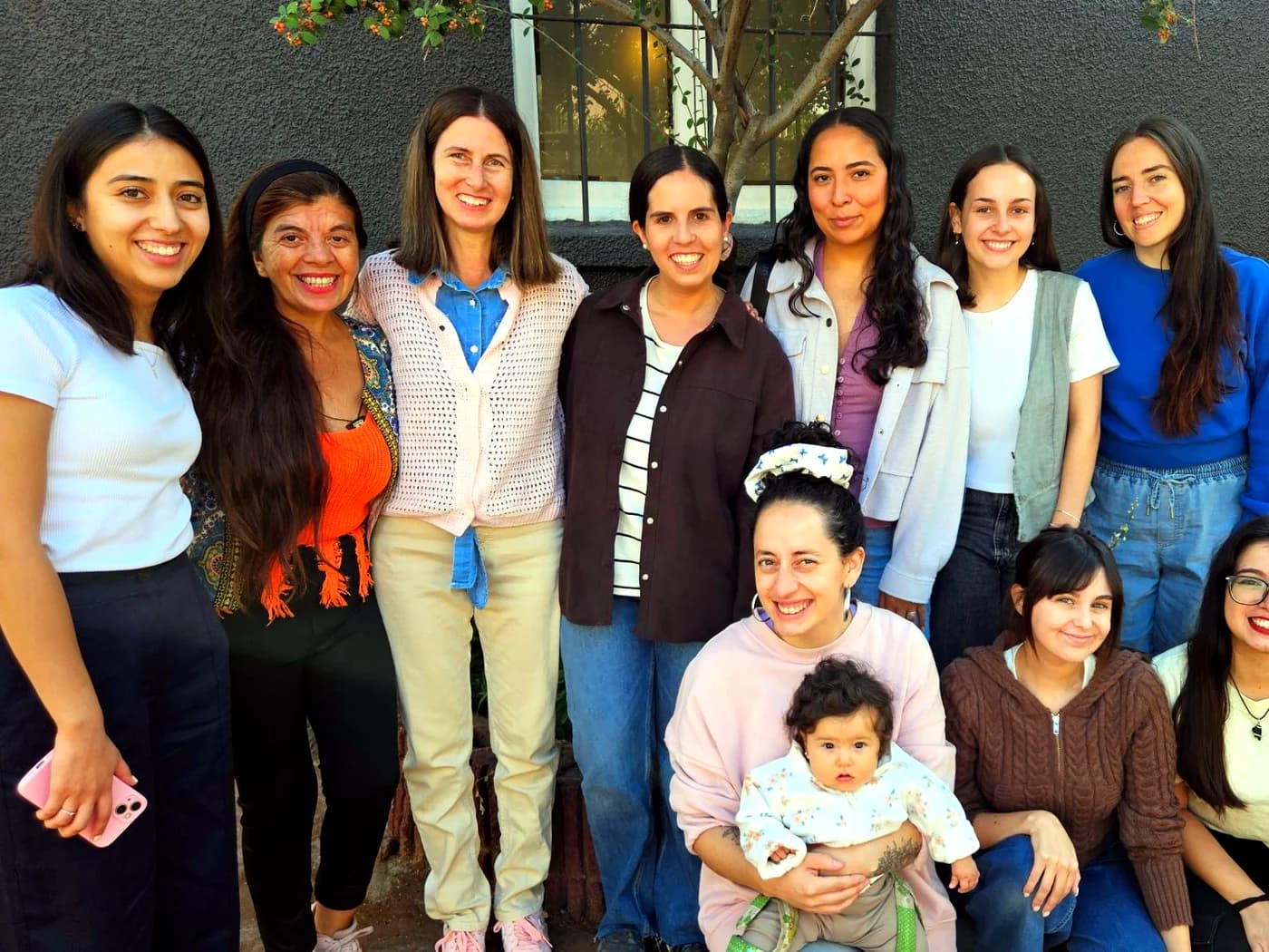 El equipo de La Casita Infancia reunido, sonriendo en el jardín.